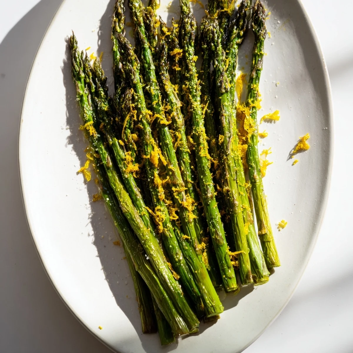 Vibrant photo: perfectly roasted asparagus, topped with tangy lemon zest and Parmesan, ready to eat.