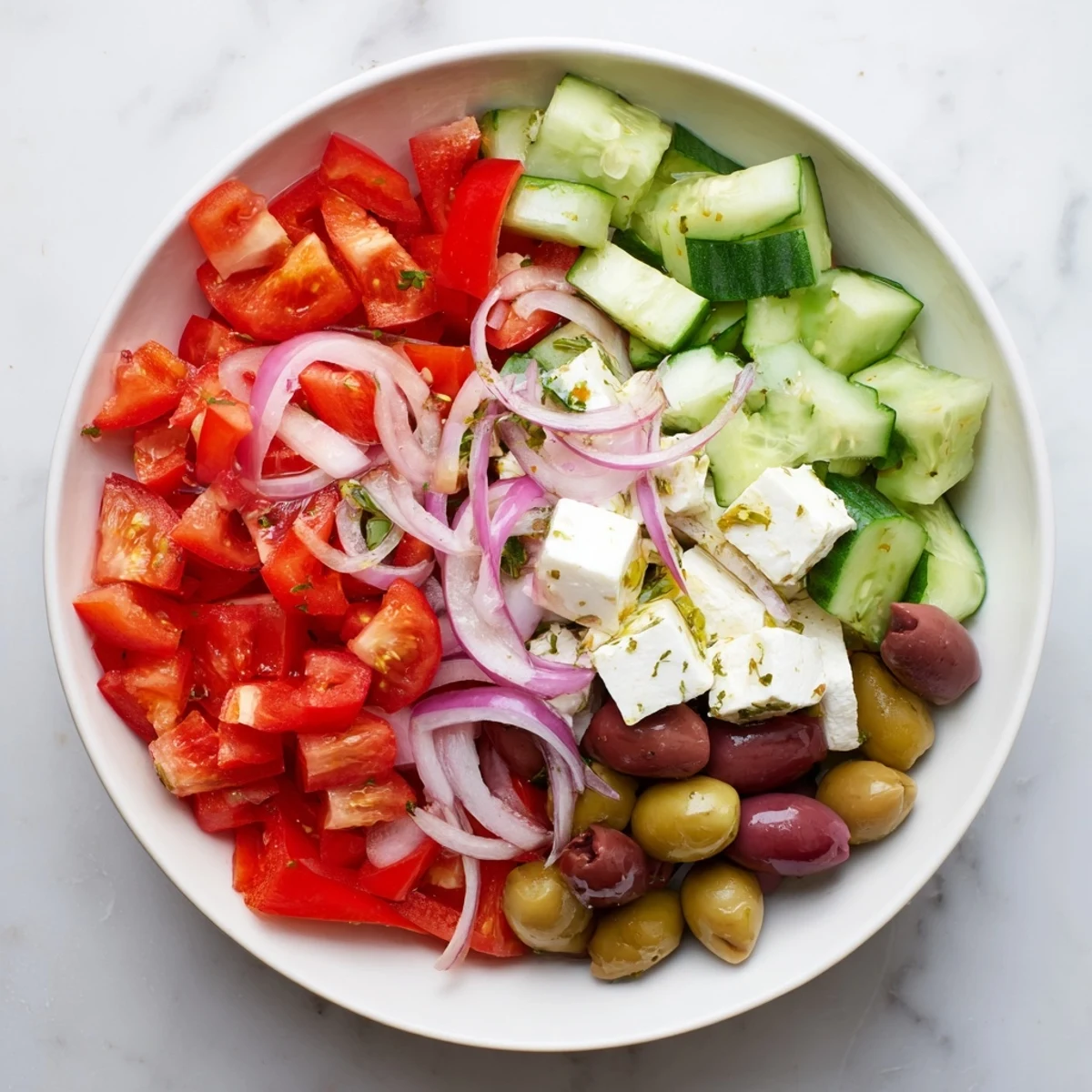 Close-up of a Fresh Mediterranean Salad showing juicy tomatoes, chickpeas, and Kalamata olives tossed in dressing.