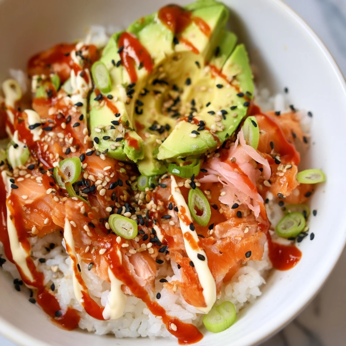 Flaked salmon and seasoned rice make up this Classic Salmon Rice bowl with fresh avocado slices.