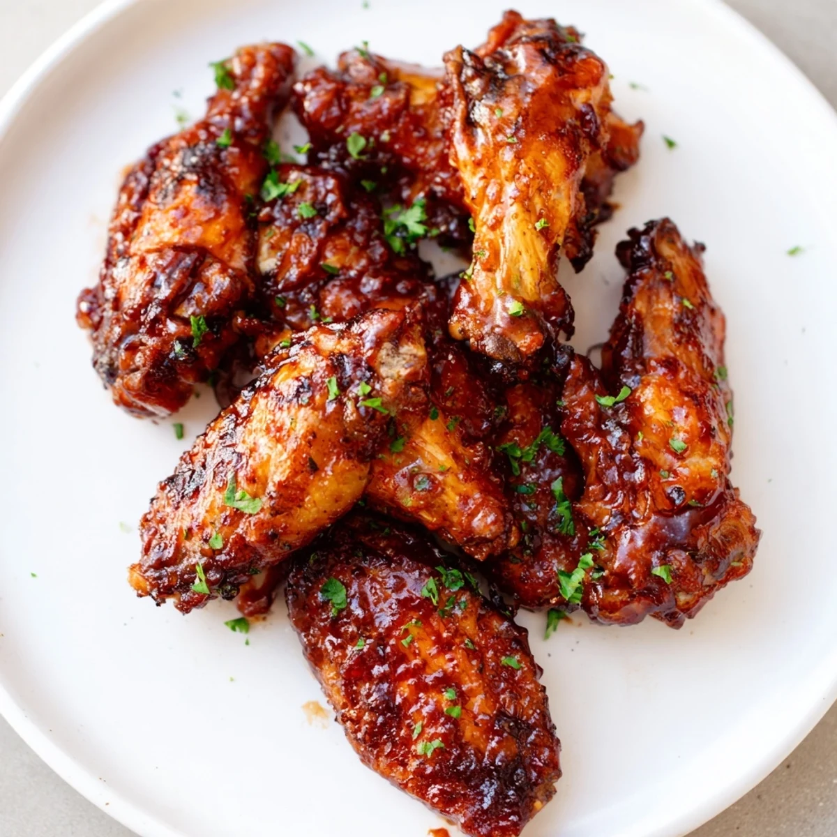 Crispy Baked Sticky Honey BBQ Wings glistening with a sweet, tangy sauce, perfect for sharing at a gathering.