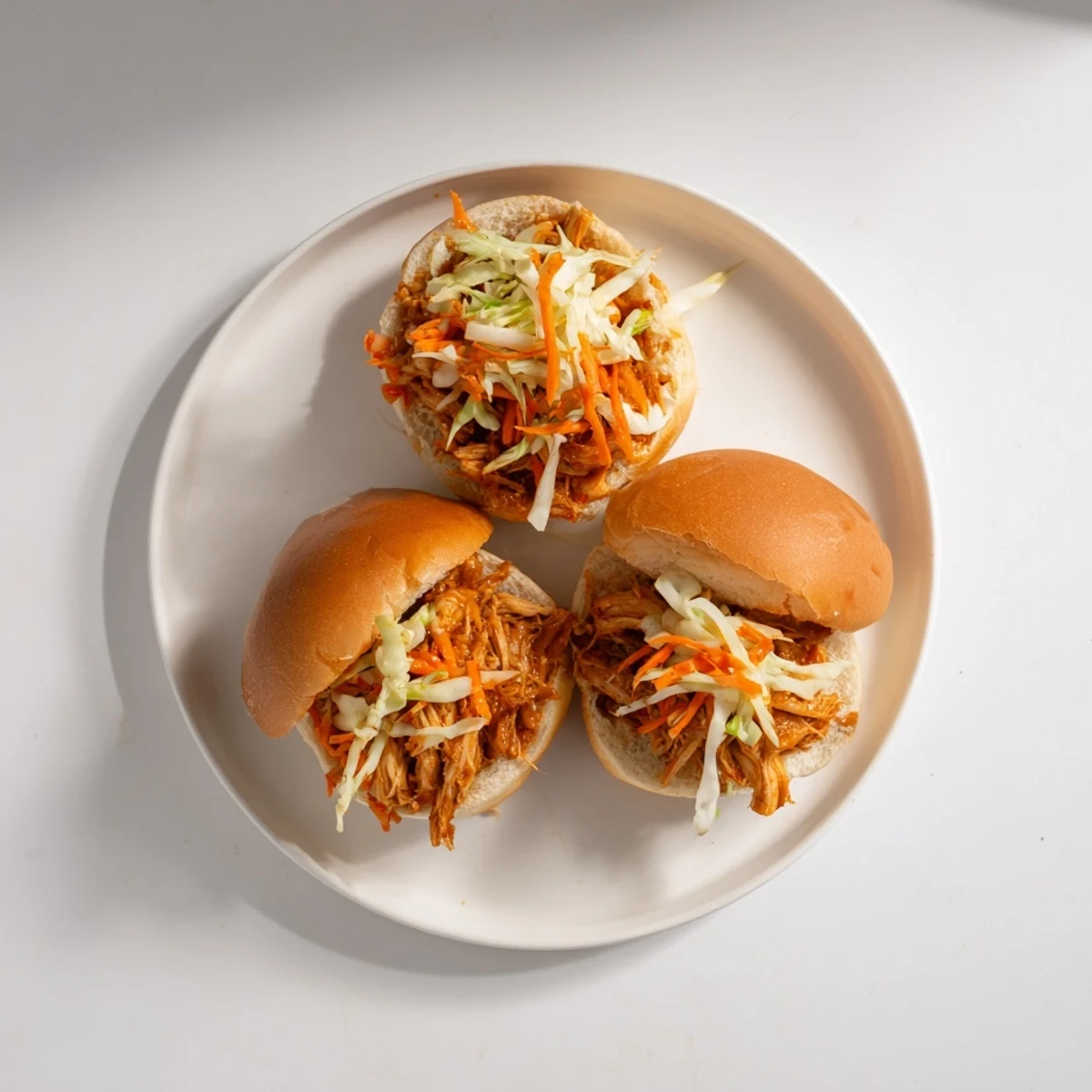 Juicy shredded chicken in smoky sauce paired with crisp slaw on soft slider buns for an easy meal.