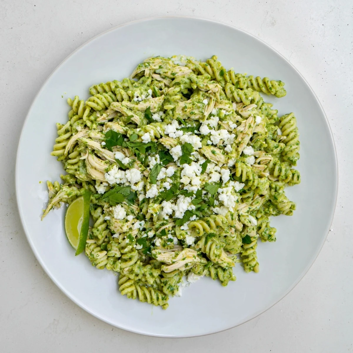 Steaming bowls of Cilantro Lime Chicken Pasta with creamy green sauce and shredded chicken tossed in rotini pasta.
