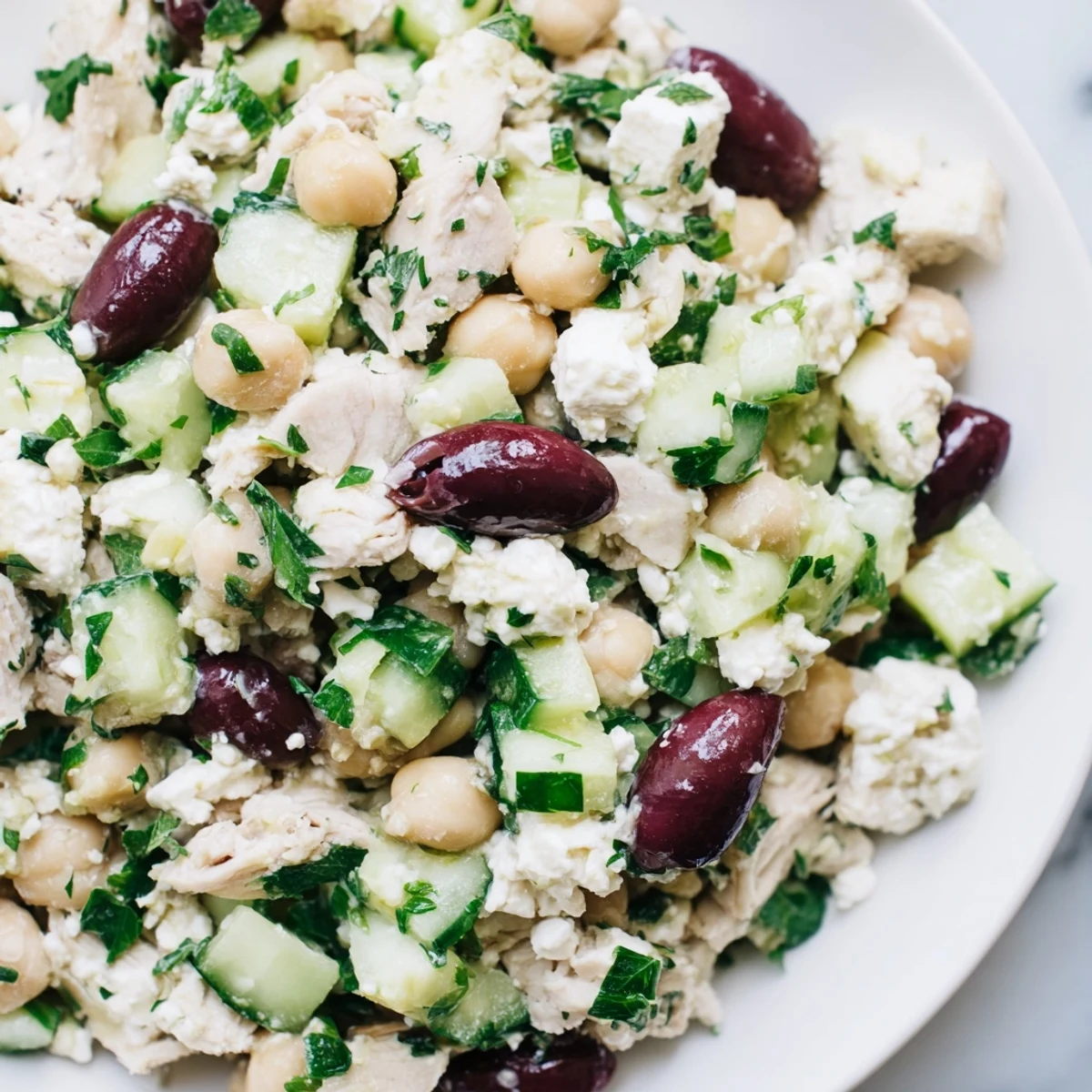 Bright Mediterranean Chickpea Chicken Salad with chickpeas, olives, and parsley served in a white bowl for a refreshing lunch.