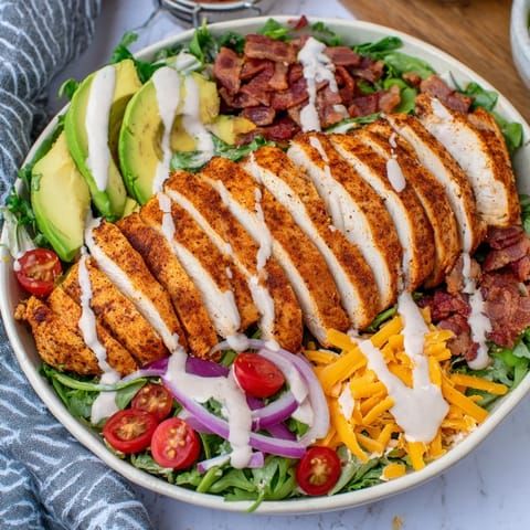 A colorful close-up of bacon chicken salad featuring juicy chicken and ripe tomatoes ready to eat.