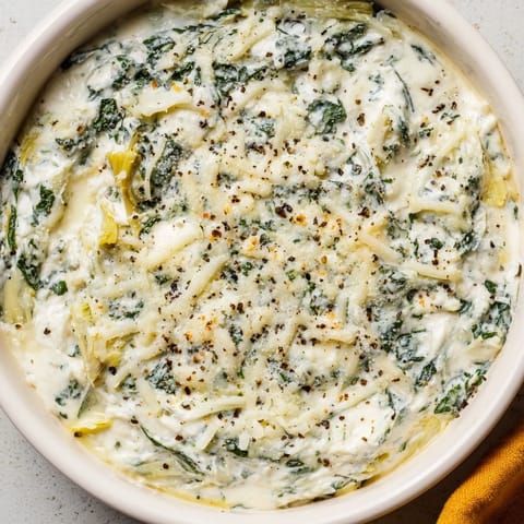 A bubbling, golden Spinach Artichoke Dip, ready to be scooped up with crispy crackers, so delicious!