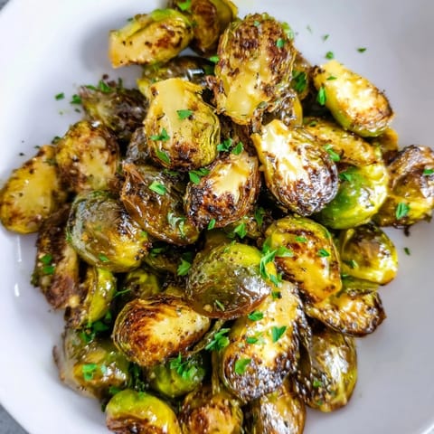 Vibrant image shows Honey Mustard Glazed Brussels Sprouts with a sweet, tangy glaze, ready to serve with parsley.