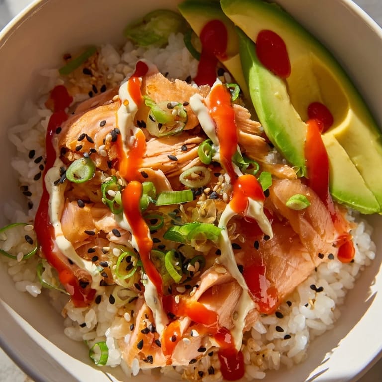 Get ready for a delicious bite: This Classic Salmon Rice bowl is topped with sesame seeds and green onions.