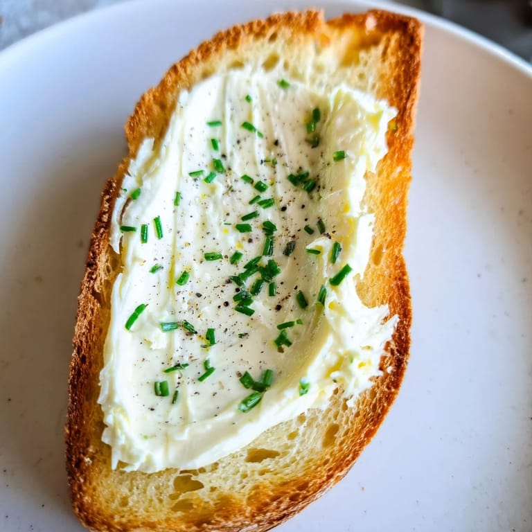 Elegant appetizer platter featuring vodka butter crostini, garnished with lemon zest and a sprinkle of black pepper.