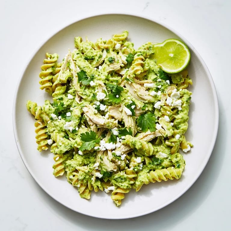 Fresh lime wedges and crumbled cotija cheese garnish this vibrant, high-protein Cilantro Lime Chicken Pasta dinner.