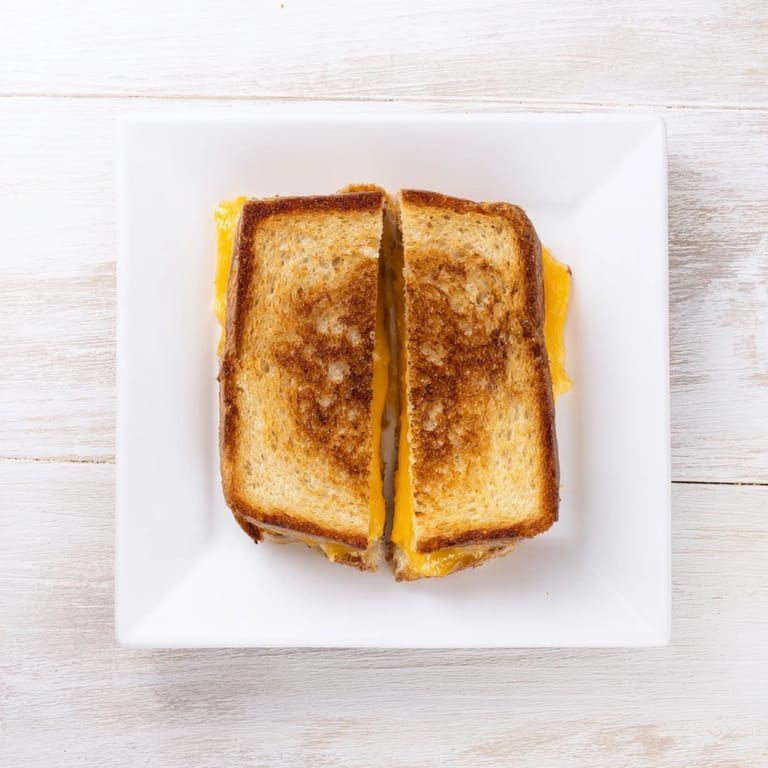 Close-up of a Triple Cheese Sourdough Grilled Cheese on a wooden board, golden crust and gooey cheese filling ready for dipping in tomato soup.